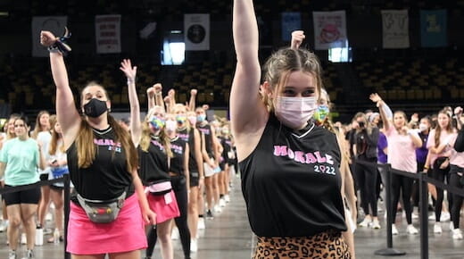 Dance team with one arm raised during performance