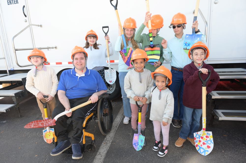 A group of children smiling and holding decorated shovels
